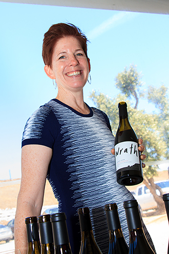 Wrath’s winemaker poses with her bottles.