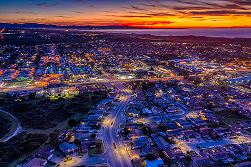 Aerial photo after sunset of the City of Marina and all its city lights with the Fort Ord Dunes, Monterey Bay and Monterey Peninsula in the background.