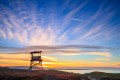 Silhouette of an old army watch tower in front of a sunset over the Monterey Peninsula.