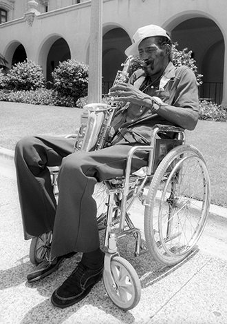 A sax player plays the blues on a hot summer afternoon in front of the Museum of Photographic Arts in San Diego. 