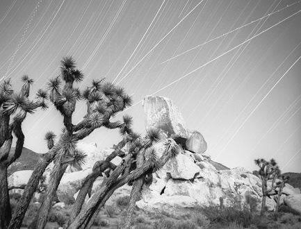 Lately I’ve taken to creating compositions that juxtapose eternal motion with the seemingly inanimate. This shot depicts 5 hours of the earth’s rotation spinning us past our universe, a host of military aircraft coming and going from the 29 Palms Marine Airbase, localized gusts of wind blowing some trees but not others, and climbers descending Head Stone Rock (the white squiggles are their headlamps)—all by 4 hours of setting moonlight and 1 hour of darkness. 