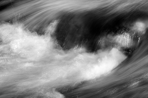 Dappled light shimmers, streaks and highlights this micro white water rapid. 