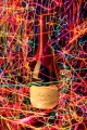 Wine bottle surrounded by hundreds of squiggles of colored lights.