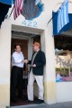 John Geoghegan shaking hands with a local restaurant owner in the restaurant doorway.
