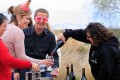 Woman pours wine for eager tasters in Valentines costumes.