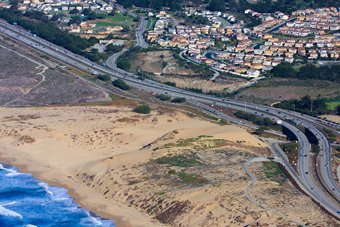 Aerial view of southern boundary of Fort Ord Dunes State Park including Highway 1, and Seaside Highlands housing area. 