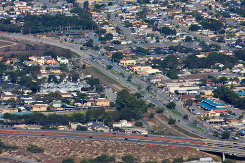 Aerial view of the City of Marina including Del Monte Avenue, Reservation Road, Highway 1, and the court house. 