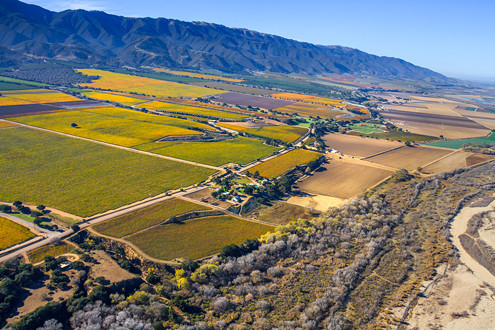 Flying between 200-1,500 feet above the famous Santa Lucia Highlands AVA in Monterey County’s Salinas Valley, this aerial photo shows River Road, Puma Road Winery, and the dry Salinas River looking north towards the Monterey Bay, and includes Pinot Noir and Chardonnay vineyards of Poppy Hillside, Hahn Lone Oak, Rosella’s, La Estancia, Silvio’s, Sumida Sisters, Vigne Borrego, and La Reine. 