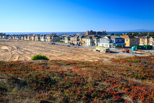 Looking northwest at 9th Avenue and new residential units with the Springhill Suites Marriot Hotel still under construction, then the Monterey Bay and Santa Cruz in the distant background. 