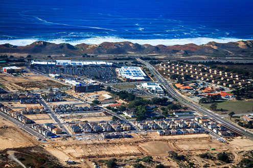 Aerial photo of nearly all of The Dunes Project Area along Highway 1. Visible clockwise from the top left: Cinemark Century Theater, Dunes Shopping Center, Imjin Parkway, 2nd Avenue, CHOMP Wellness Center, Imjin Office Park, Veterans Transition Center, 3rd Avenue, 10th Street, 9th Street, The Dunes Housing, Springhill Suites Marriot, and The Dunes Food Court. 