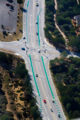Aerial photo of traffic on a road with distinctly green painted bike lanes.