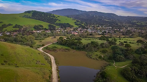 Aerial photo Boy Scout Pond on the southern edge of the Fort Ord National Monument with the Toro Park neighborhood and county park in the background from a drone. 
