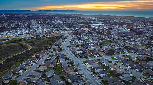 Aerial photo of Marina residential neighborhood with sunset over the Monterey Peninsula and Bay from a drone. 