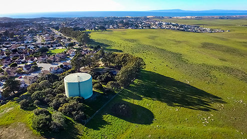Aerial photo of Marina residential neighborhood with Armstrong Ranch, and the Monterey Bay and Santa Cruz in the background from a drone. 