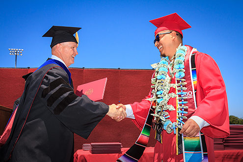 Monterey Peninsula College President Dr. Walter Tribley hands a graduate his diploma and congratulated him. I took more than 800 photos of nearly 400 graduates receiving their diplomas in about 1 hour—very faced paced event coverage. 