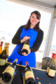 A winemaker poses with her bottles.