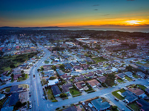 Looking south down Crescent Avenue towards the Reservation Road downtown corridor at sunset with the Fort Ord Dunes, Monterey Bay and Monterey Peninsula in the background. FAA certified sUAS/Drone photography.  