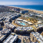 Drone photo of a city-block-size apartment complex near the beach under construction.