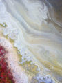 Abstract aerial drone photo looking directly down at colorful swirling patterns in the brackish water and foliage of a salt marsh.