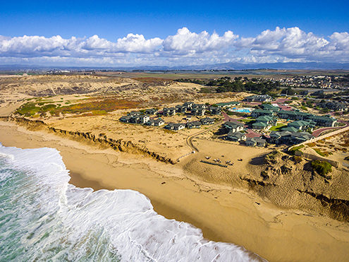 Aerial view of the hotel and time shares located along Dunes Drive in the City of Marina, Marina State Beach, and Fremont Peak in the distance. 