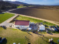 Aerial photo from about 100 feet above a River Road Wine Trail Valentines Passport festivities with vineyards and mountains in the background.
