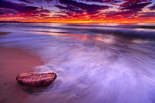 The incoming tide reflects the purple twilight sky above the Monterey Bay. 
