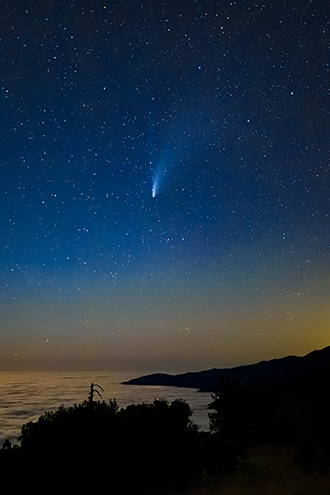 The Big Sur coast with the Neowise Comet zooming by on Thursday, July 23, 2020 from about 3,000 feet above sea level. That's not the ocean, it's the top of the fog layer blocking all the beach campers from getting to see this. The little bright spot at the edge of the coast directly below the comet are the lights of Lucia glowing below the fog.  