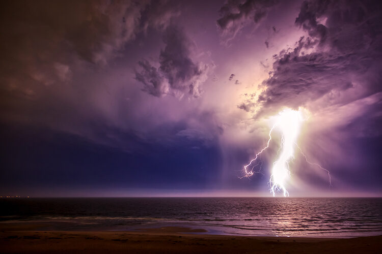 Photo of lightning over the ocean that illustrates the raw power of nature