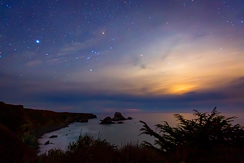 A combination of clouds, sunset and stars creates the illusion that we are orbiting the Milky Way Galaxy hub. 